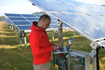 Image showing engineer using laptop at solar panels plant field