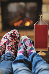 Image showing Young romantic couple sitting and relaxing in front of fireplace