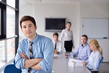 Image showing business man  on a meeting in offce with colleagues in backgroun