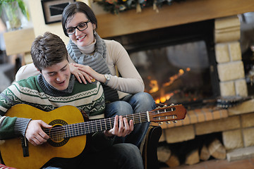 Image showing Young romantic couple sitting and relaxing in front of fireplace