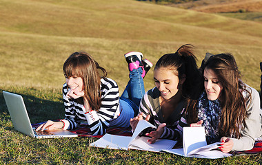 Image showing group of teens working on laptop outdoor