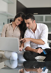 Image showing joyful couple relax and work on laptop computer at modern home