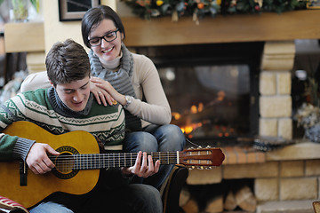 Image showing Young romantic couple sitting and relaxing in front of fireplace