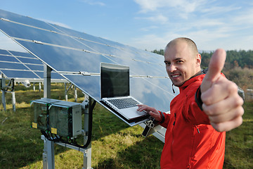 Image showing engineer using laptop at solar panels plant field