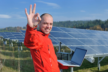 Image showing engineer using laptop at solar panels plant field