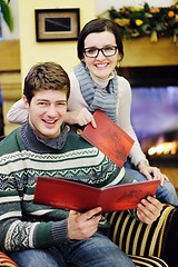 Image showing Young romantic couple relax on sofa in front of fireplace at hom