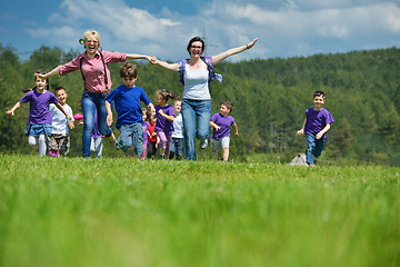 Image showing happy kids group with teacher in nature