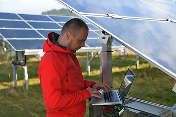 Image showing engineer using laptop at solar panels plant field