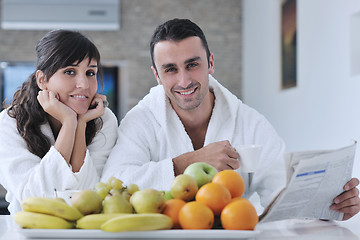 Image showing Happy couple reading the newspaper in the kitchen at breakfast