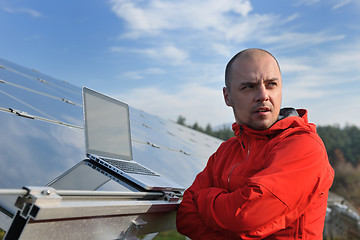 Image showing engineer using laptop at solar panels plant field