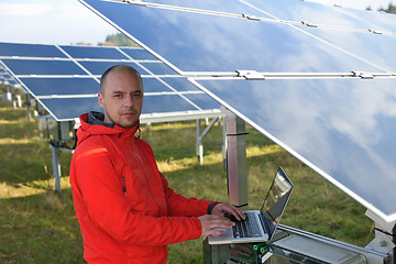 Image showing engineer using laptop at solar panels plant field