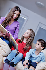 Image showing young mom play with their kids at home and reading book