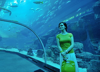 Image showing young woman with big aquarium in backgrond