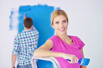 Image showing happy couple paint wall at new home