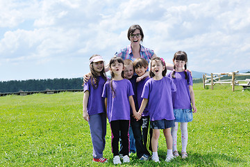 Image showing happy kids group with teacher in nature