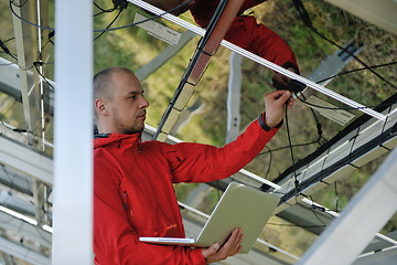 Image showing engineer using laptop at solar panels plant field