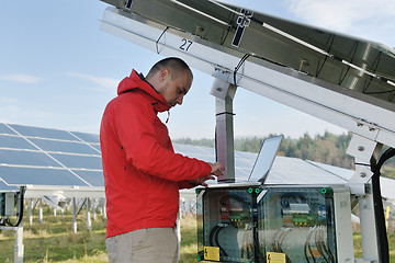 Image showing engineer using laptop at solar panels plant field