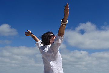 Image showing happy young woman with spreading arms to sky