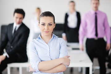 Image showing business woman standing with her staff in background