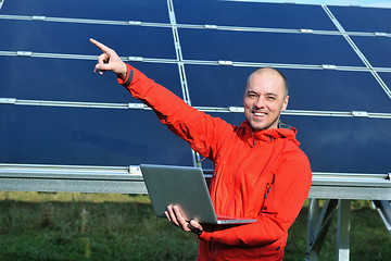 Image showing engineer using laptop at solar panels plant field