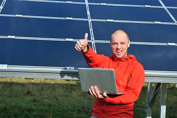 Image showing engineer using laptop at solar panels plant field