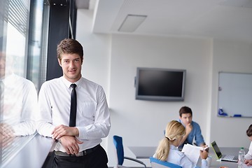 Image showing business man  on a meeting in offce with colleagues in backgroun