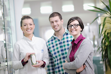 Image showing pharmacist suggesting medical drug to buyer in pharmacy drugstor