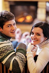 Image showing Young romantic couple relax on sofa in front of fireplace at hom