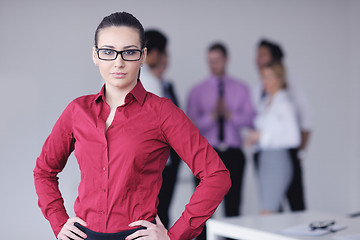 Image showing business woman standing with her staff in background