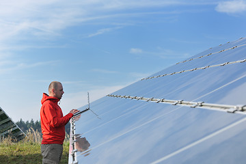 Image showing engineer using laptop at solar panels plant field