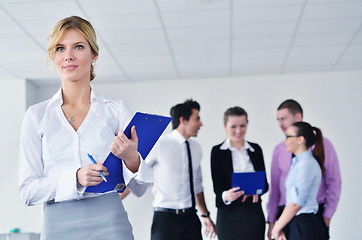 Image showing business woman standing with her staff in background