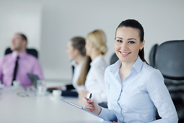 Image showing business woman standing with her staff in background