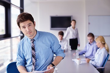 Image showing business man  on a meeting in offce with colleagues in backgroun