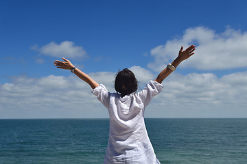 Image showing happy young woman with spreading arms to sky