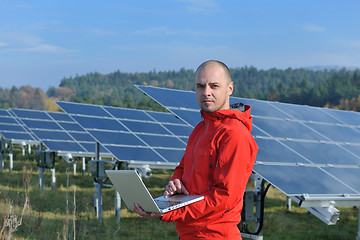 Image showing engineer using laptop at solar panels plant field