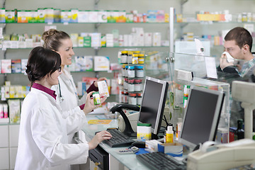 Image showing pharmacist suggesting medical drug to buyer in pharmacy drugstor