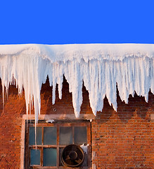 Image showing Snow cover on roof of old textile fabric with icicles, deep blue