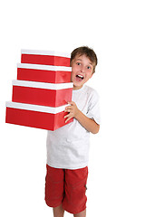 Image showing Excited child carrying gift boxes