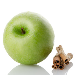Image showing Ripe green apple with cinnamon sticks