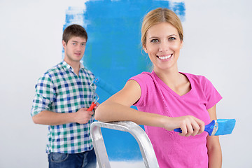 Image showing happy couple paint wall at new home