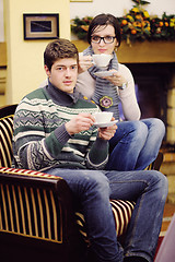 Image showing Young romantic couple sitting and relaxing in front of fireplace