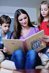 Image showing young mom play with their kids at home and reading book