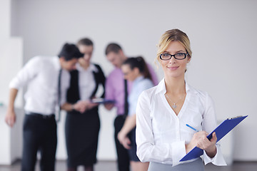 Image showing business woman standing with her staff in background