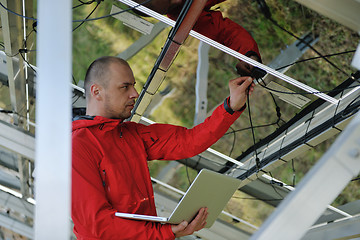 Image showing engineer using laptop at solar panels plant field