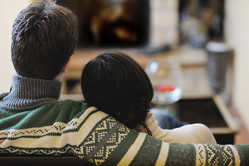 Image showing Young romantic couple sitting and relaxing in front of fireplace