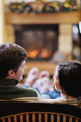 Image showing Young romantic couple sitting and relaxing in front of fireplace