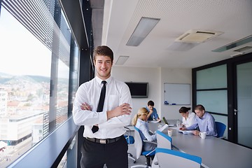 Image showing business man  on a meeting in offce with colleagues in backgroun