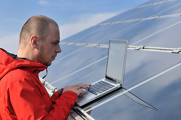 Image showing engineer using laptop at solar panels plant field