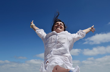 Image showing happy young woman with spreading arms to sky