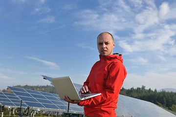 Image showing engineer using laptop at solar panels plant field